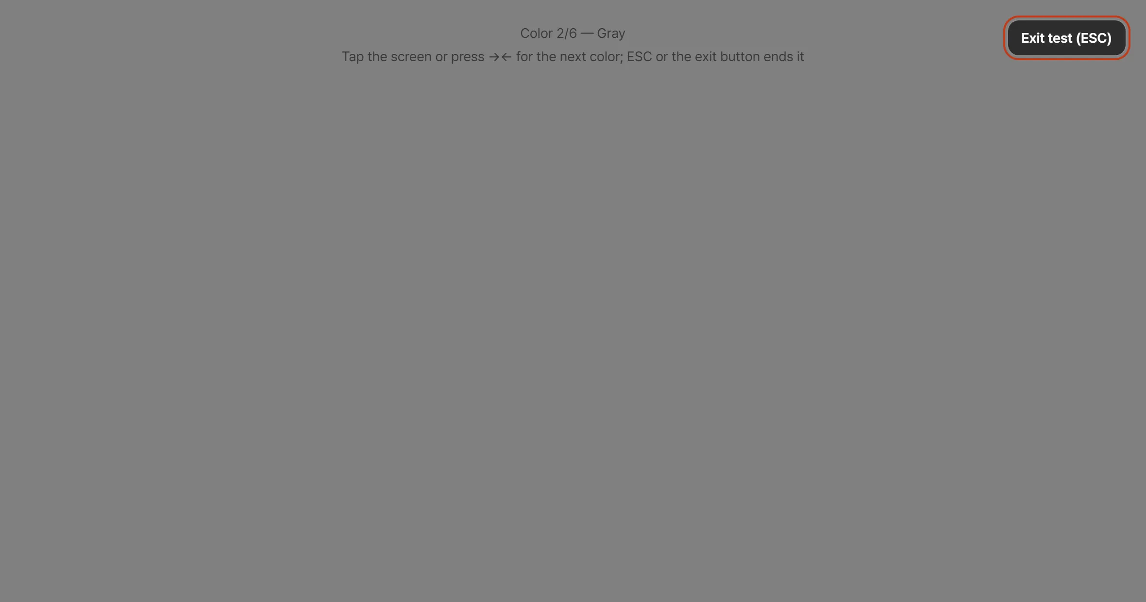 The dead pixel test showing a full-screen gray field. A line at the top reads “Color 2/6 — Gray” with the hint to tap or press the arrow keys for the next color, and an exit button sits in the top right.